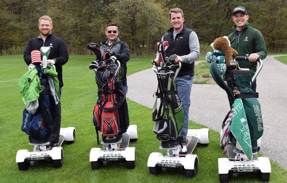 A fourball with their golf bags loaded on GolfBoards